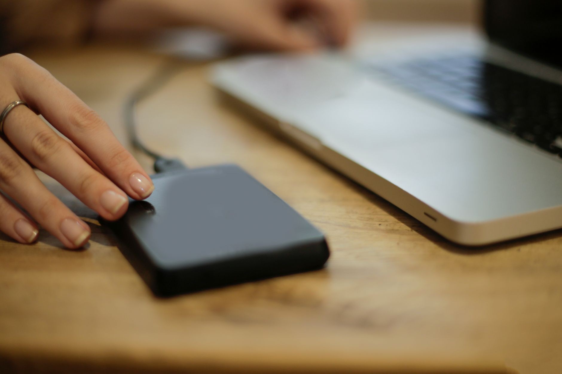 Personne qui branche un disque dur externe sur un ordinateur portable pour vérifier le câble et la connexion